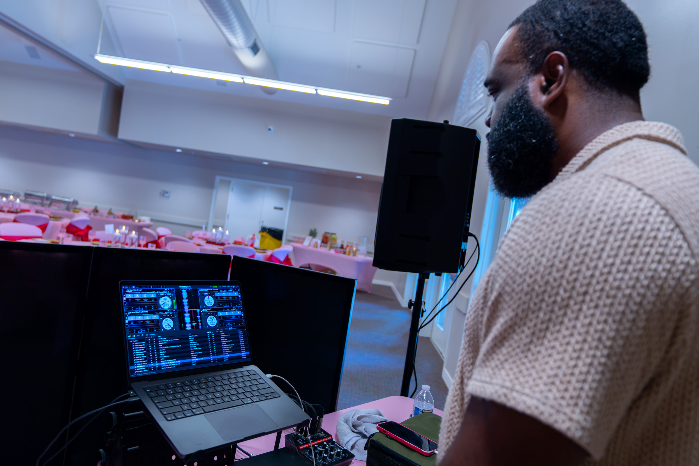 DJ booth set up at a banquet, room laid out behind