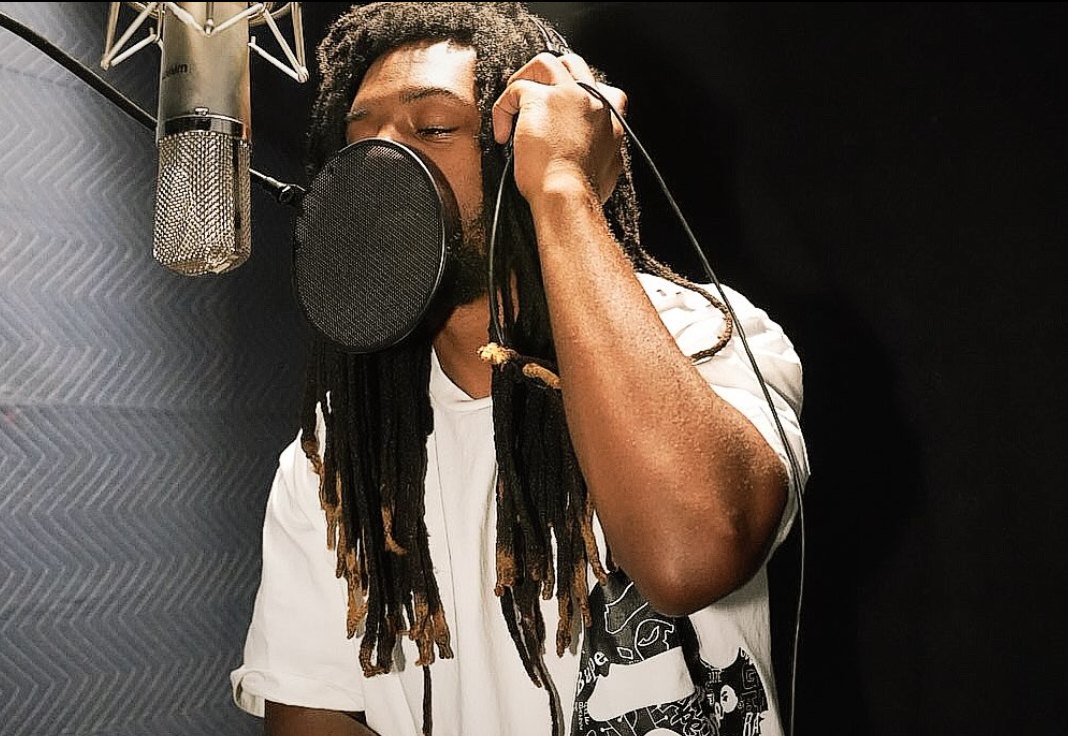 Vocalist tracking at the microphone in the booth